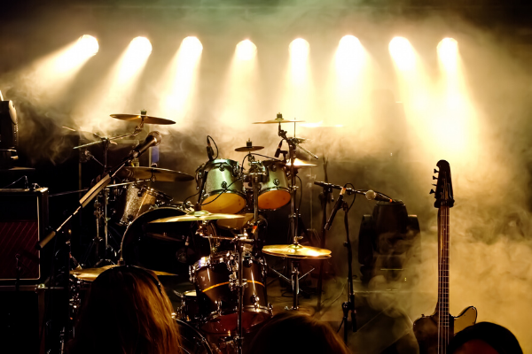 Instruments on a stage with lights and a smoke machine.