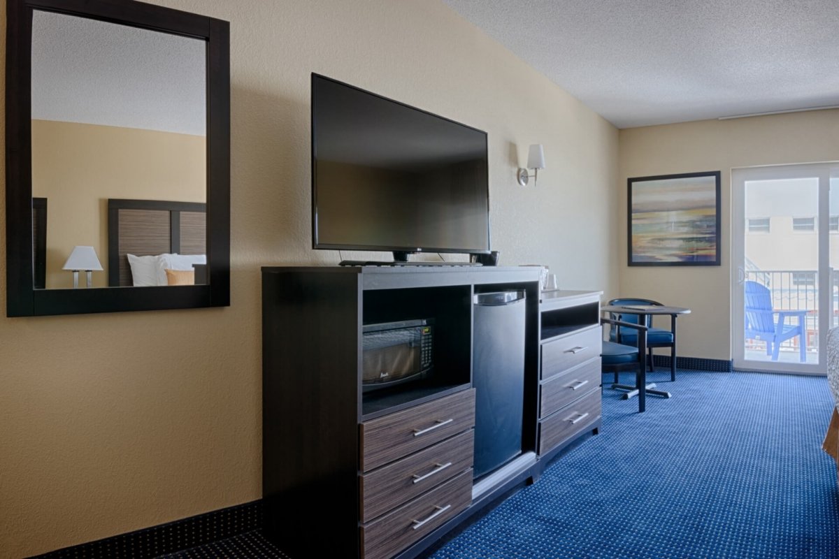 a hotel room with a flat screen tv and dresser
