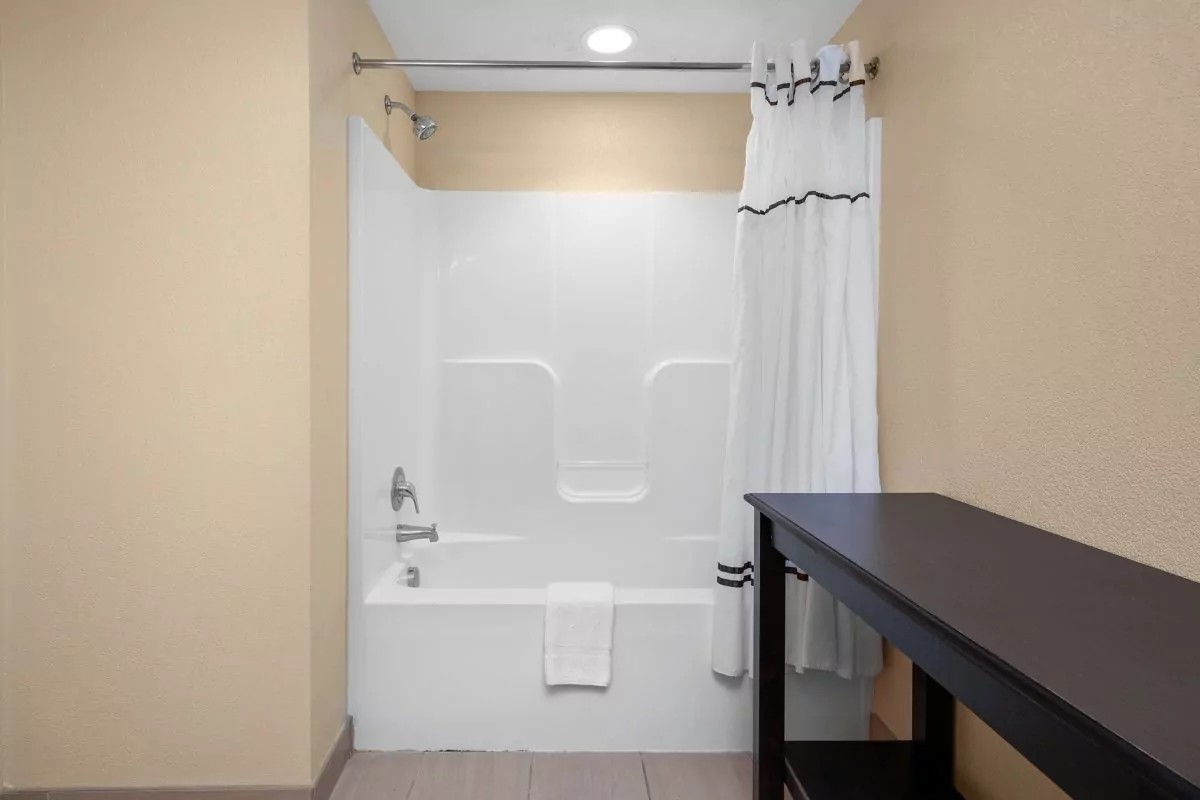 a white bath tub sitting next to a wooden table