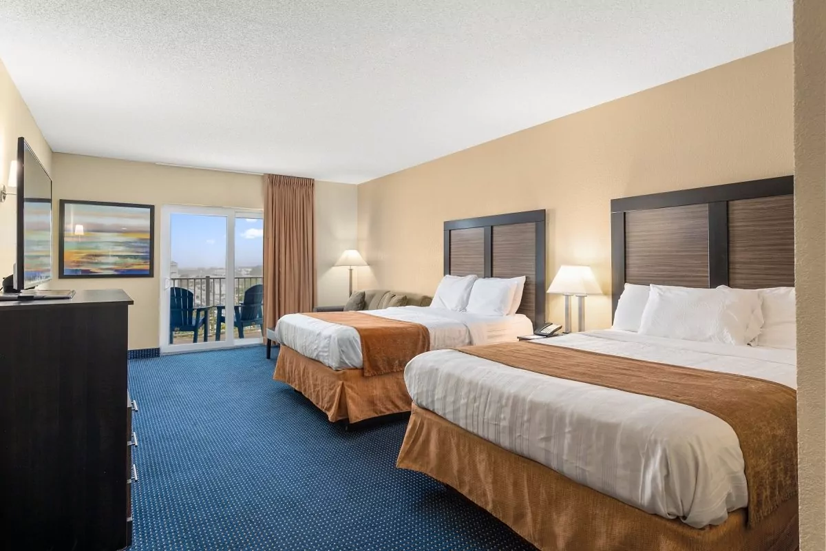 a hotel room with two beds and a flat screen tv
