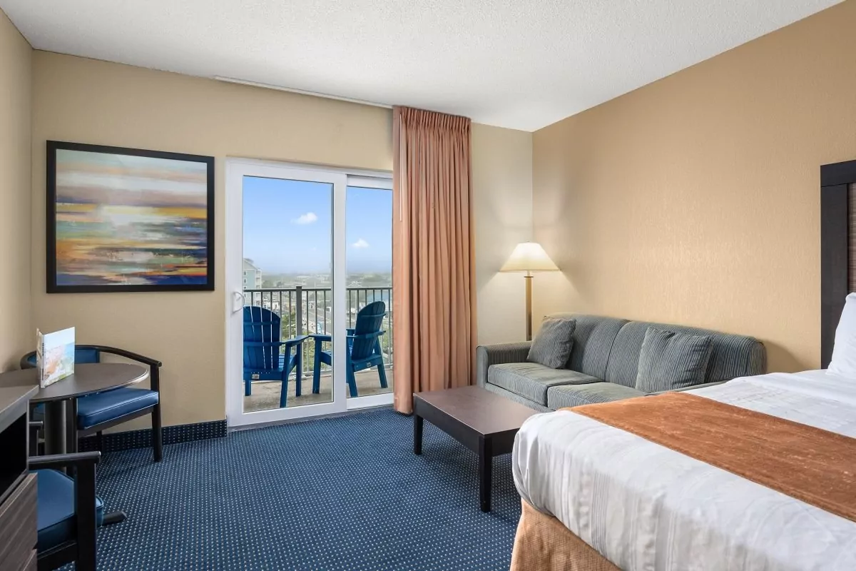 a hotel room with a bed, couch and television
