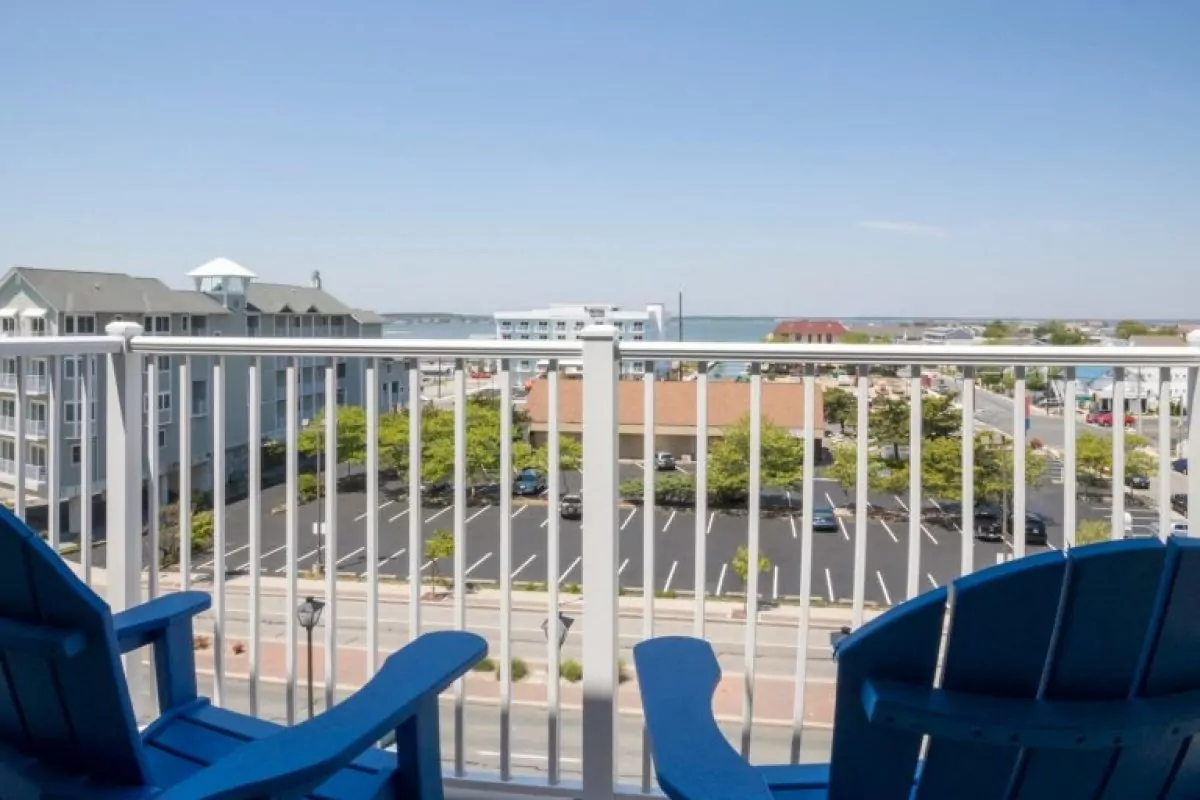 two blue chairs sitting on top of a balcony